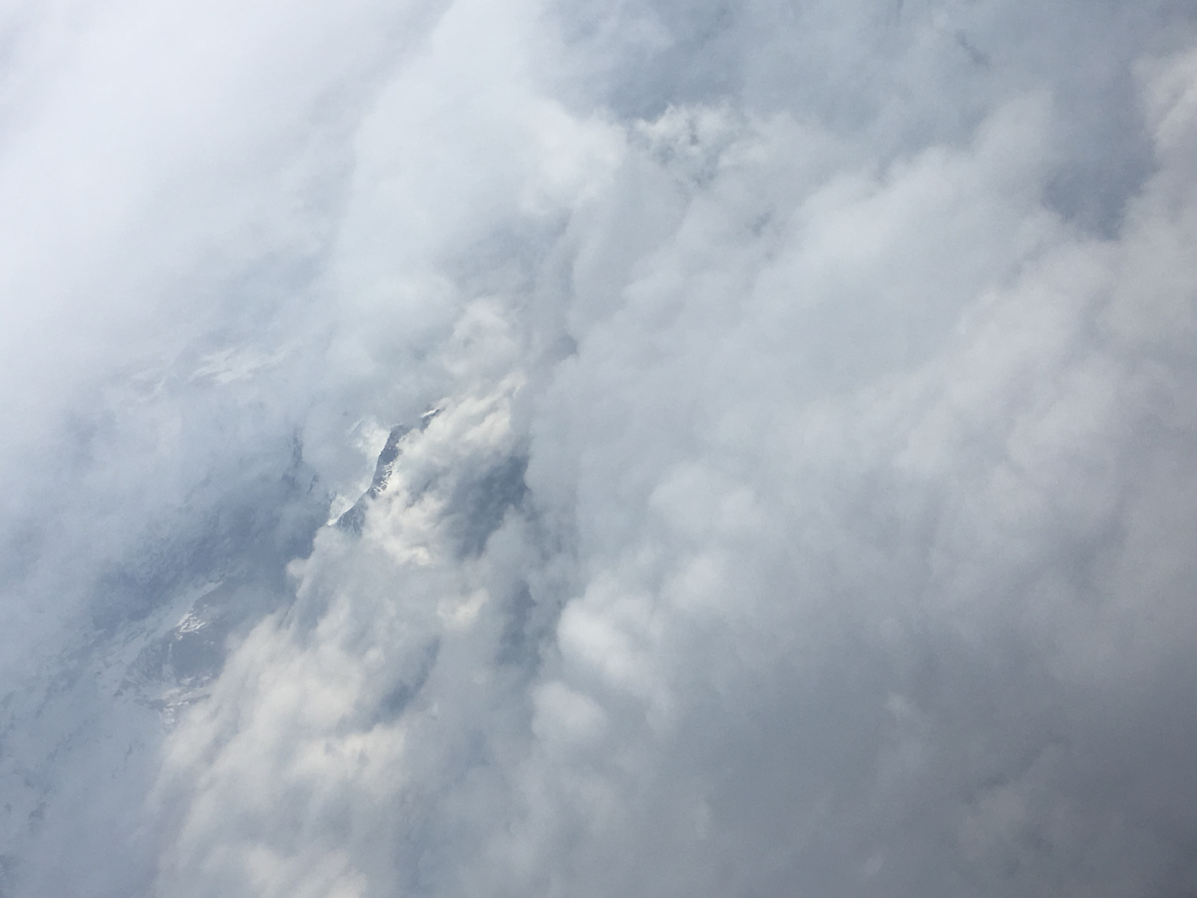 Photograph of mountains in clouds as seen from the air